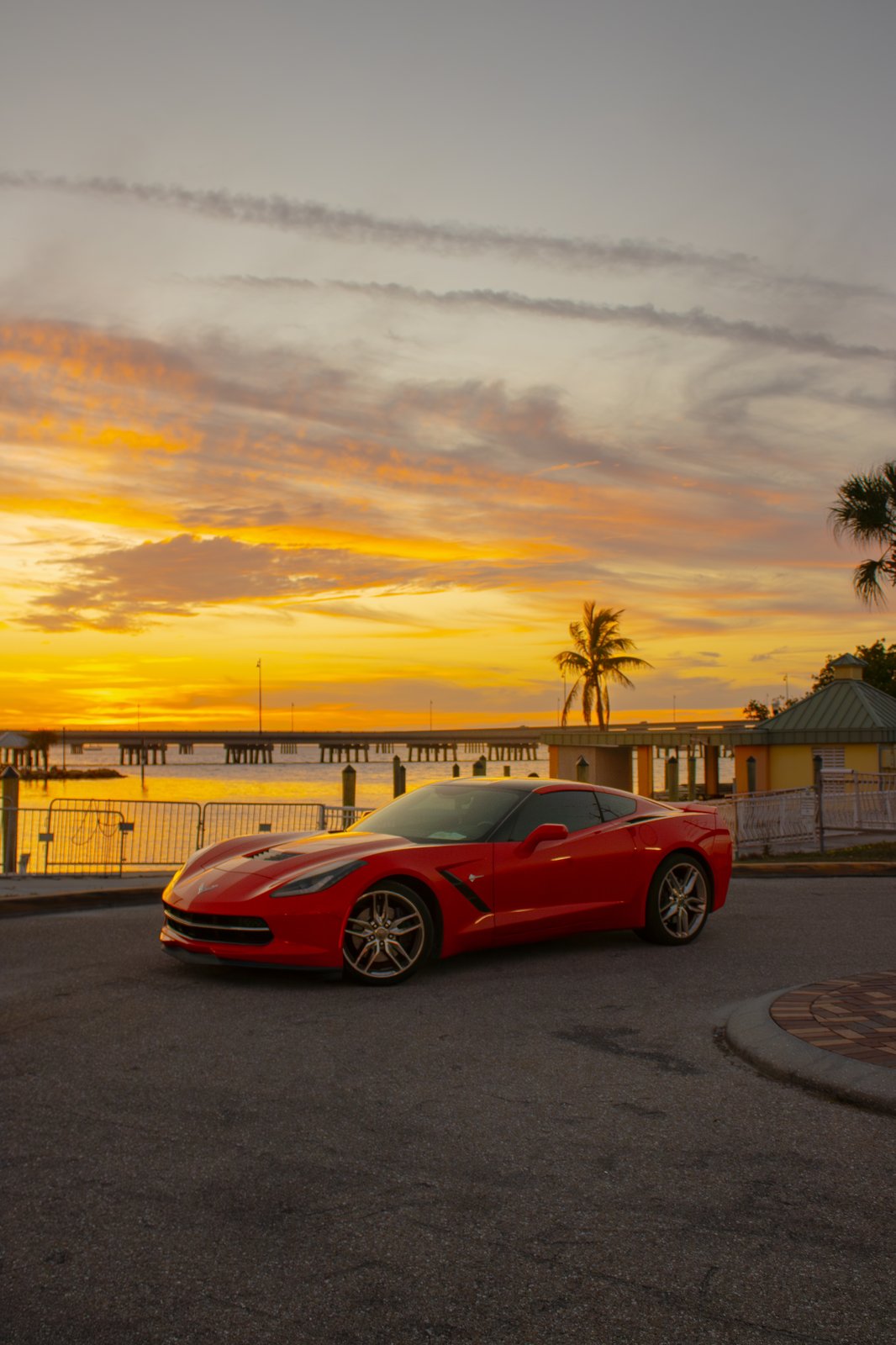Red Corvette Stingray vertical portrait against a vibrant Florida sunset sky