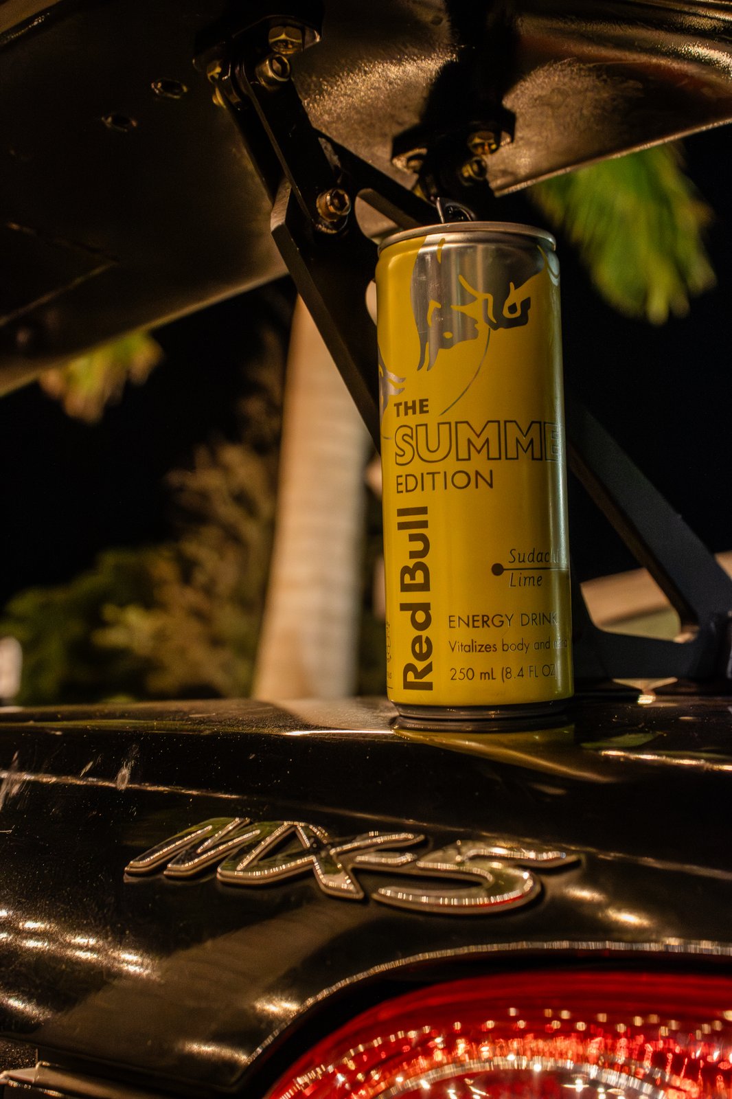 Red Bull Summer Edition can on Mazda MX-5 trunk lid at night — cinematic lifestyle shot